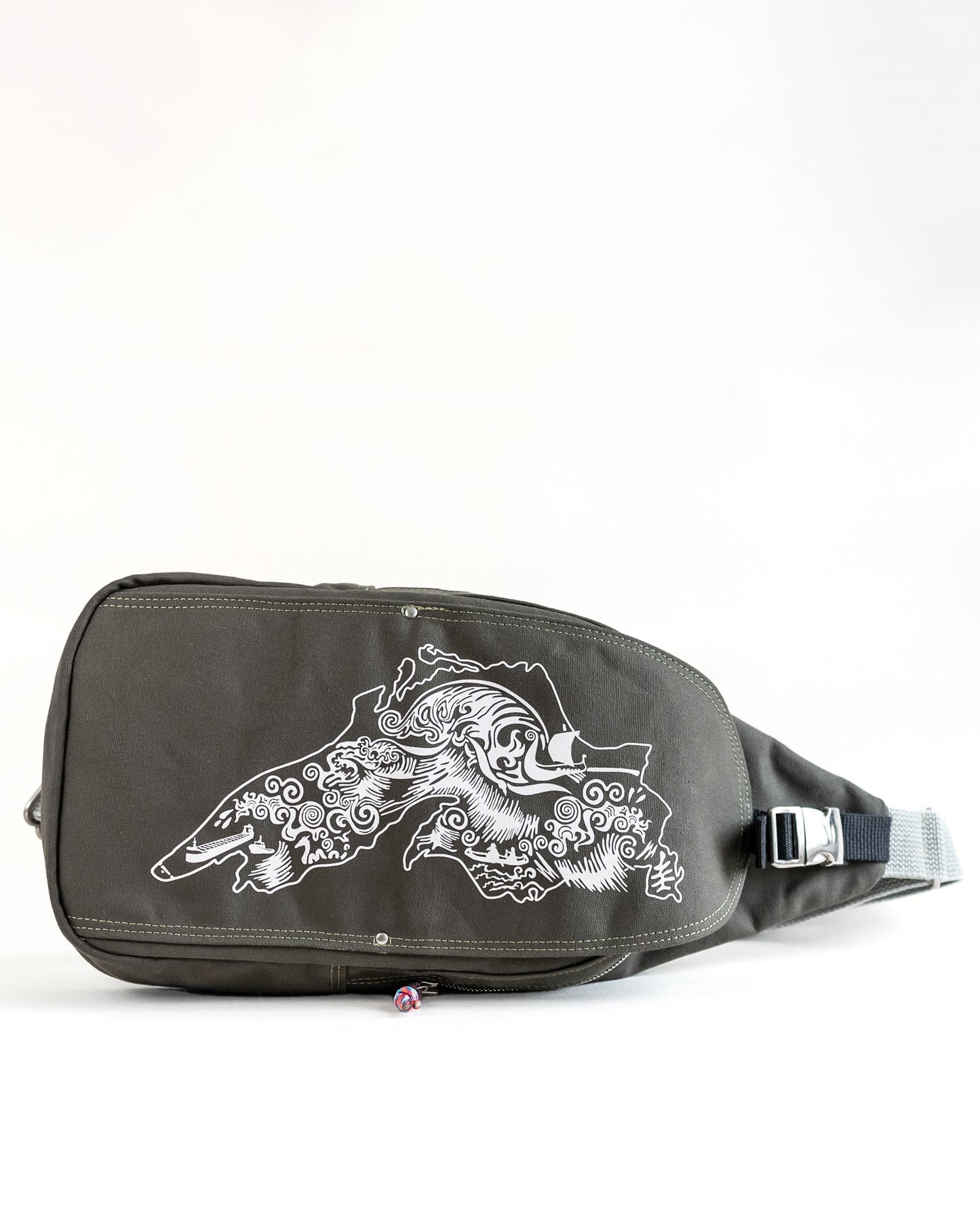 Front exterior of Dock 5’s Lake Superior Canvas Sling Bag in olive featuring art from owner Natalija Walbridge