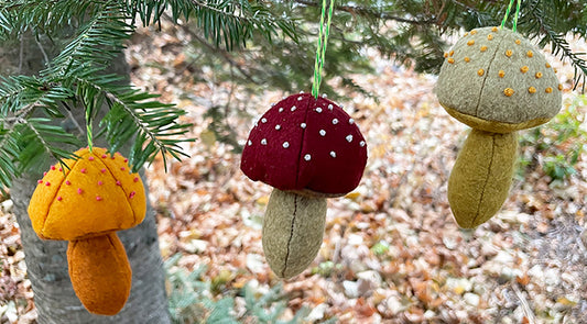 Felt mushrooms hanging on a pine branch