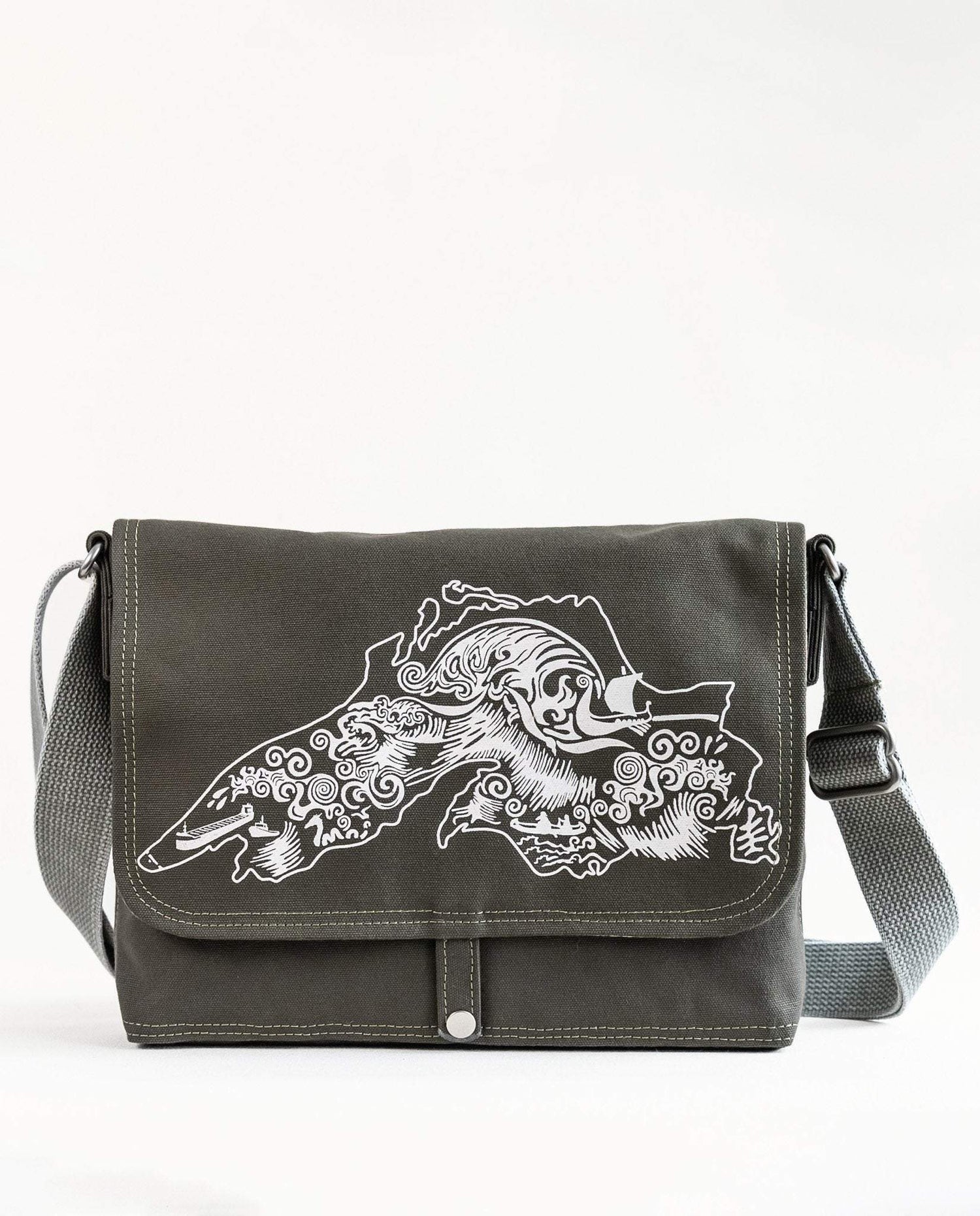 Front exterior of Dock 5’s Lake Superior Canvas Messenger Bag in olive featuring art from owner Natalija Walbridge