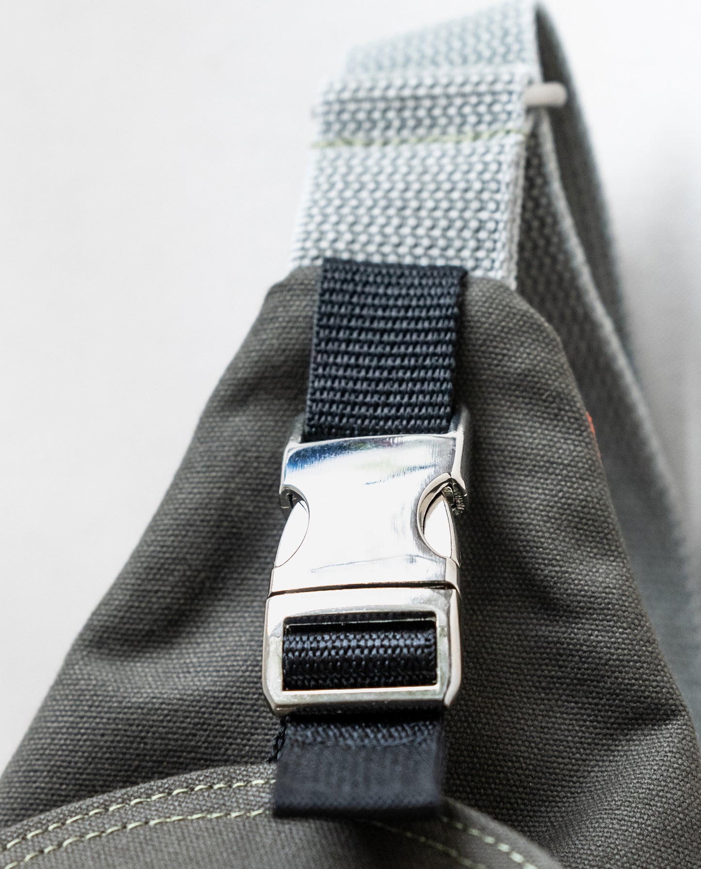 An aluminum side-squeeze buckle secures the front flap of Dock 5’s spacious, hand-sewn Dragonfly Canvas Sling Bag