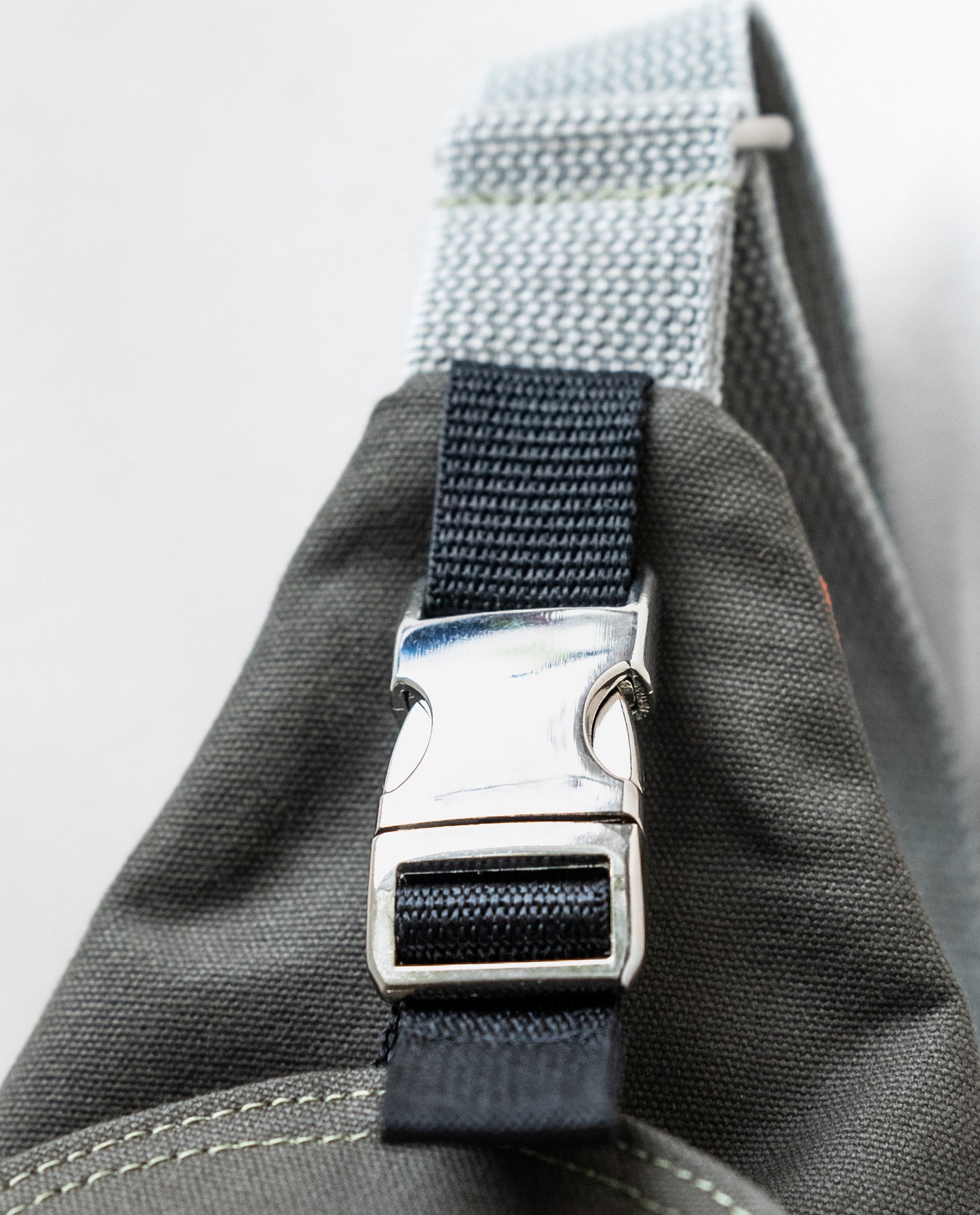 An aluminum side-squeeze buckle secures the front flap of Dock 5’s spacious, hand-sewn Kingfisher Canvas Sling Bag