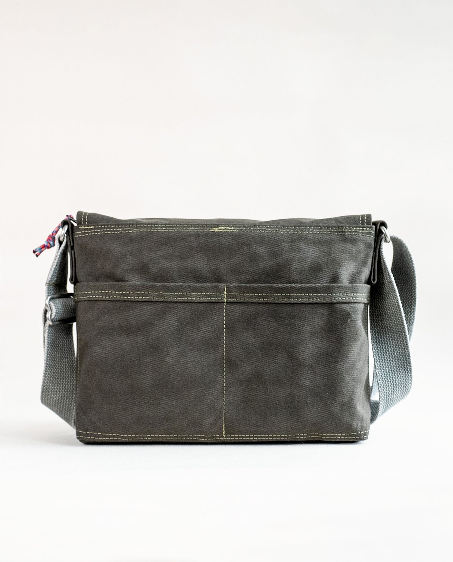 Back exterior pockets of Dock 5’s Chickadee Canvas Messenger Bag in olive featuring art from owner Natalija Walbridge