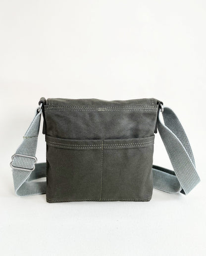 Back exterior pockets of Dock 5’s Chickadee Canvas Mini Messenger Bag in olive featuring art from owner Natalija Walbridge