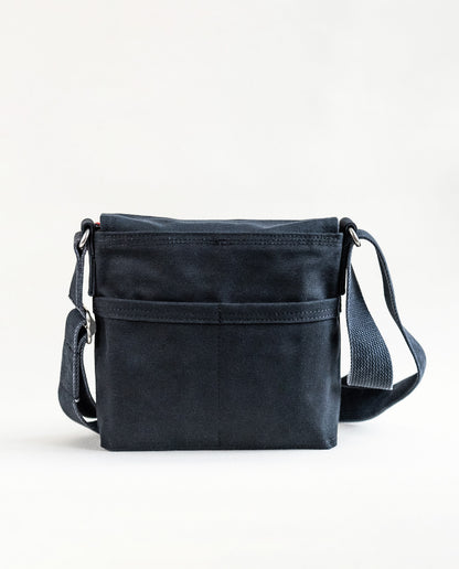 Back exterior pockets of Dock 5’s Lift Bridge Canvas  Mini Messenger Bag in black featuring art from owner Natalija Walbridge