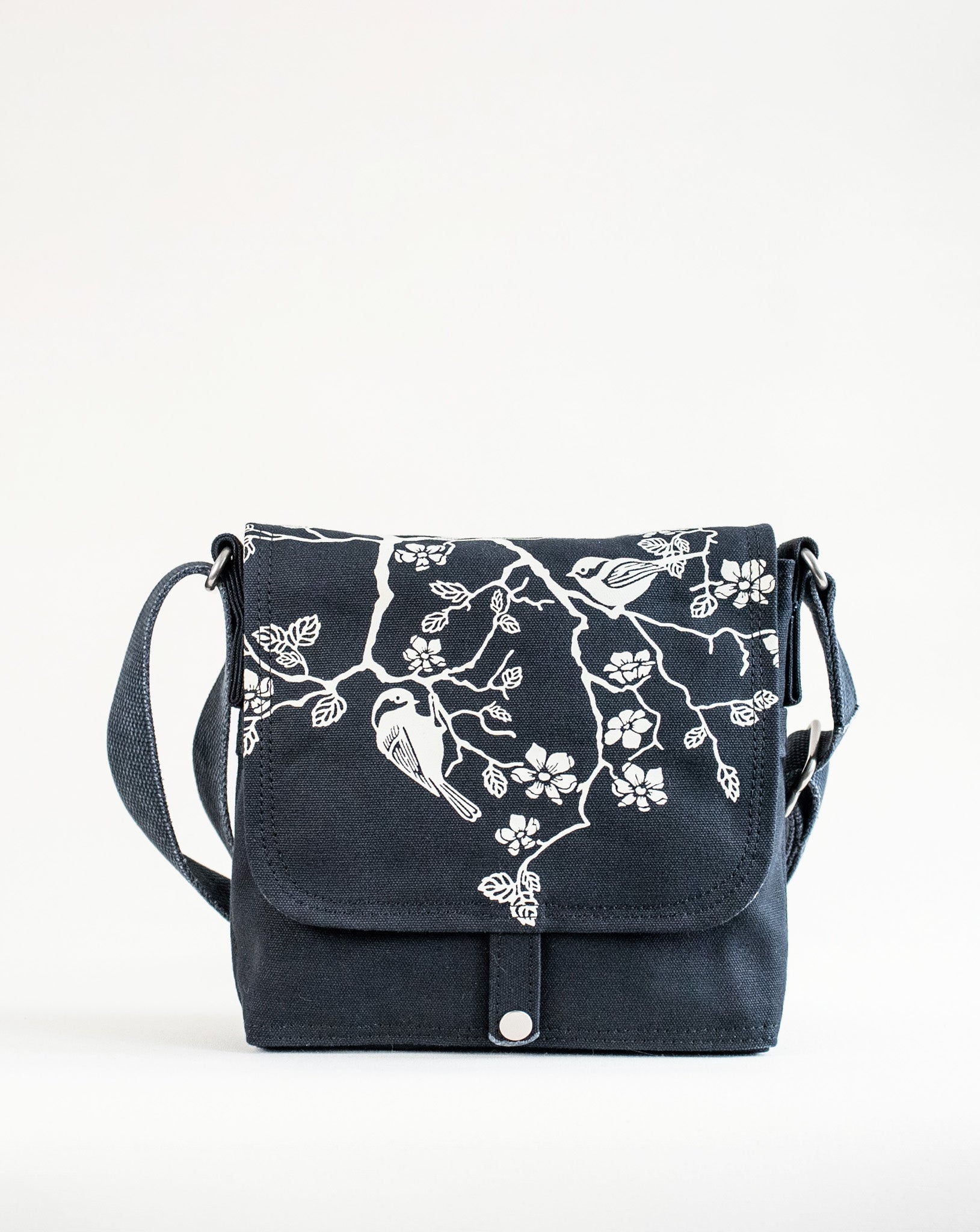 Front exterior of Dock 5’s Chickadee Canvas Mini Messenger Bag in black featuring art from owner Natalija Walbridge