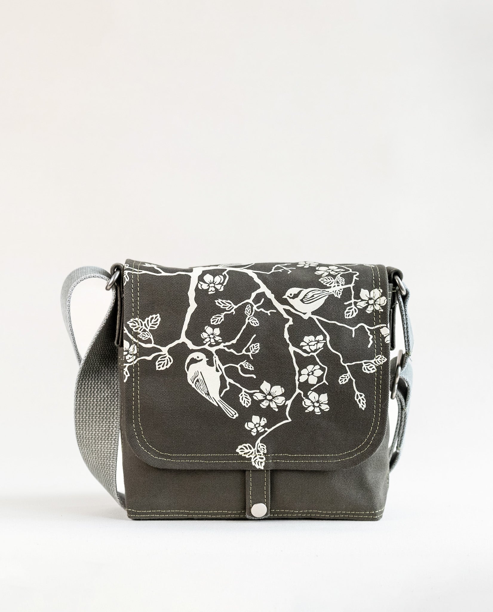 Front exterior of Dock 5’s Chickadee Canvas Mini Messenger Bag in olive featuring art from owner Natalija Walbridge