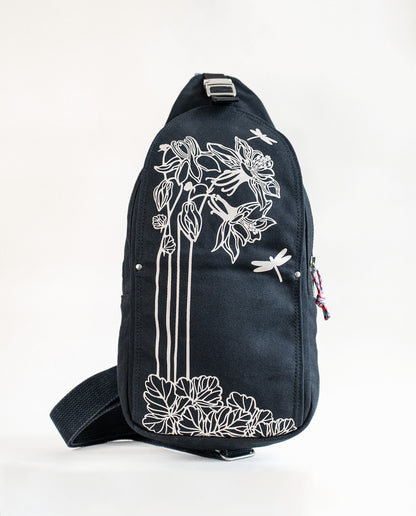 Front exterior of Dock 5’s Dragonfly  Canvas Sling Bag in black featuring art from owner Natalija Walbridge