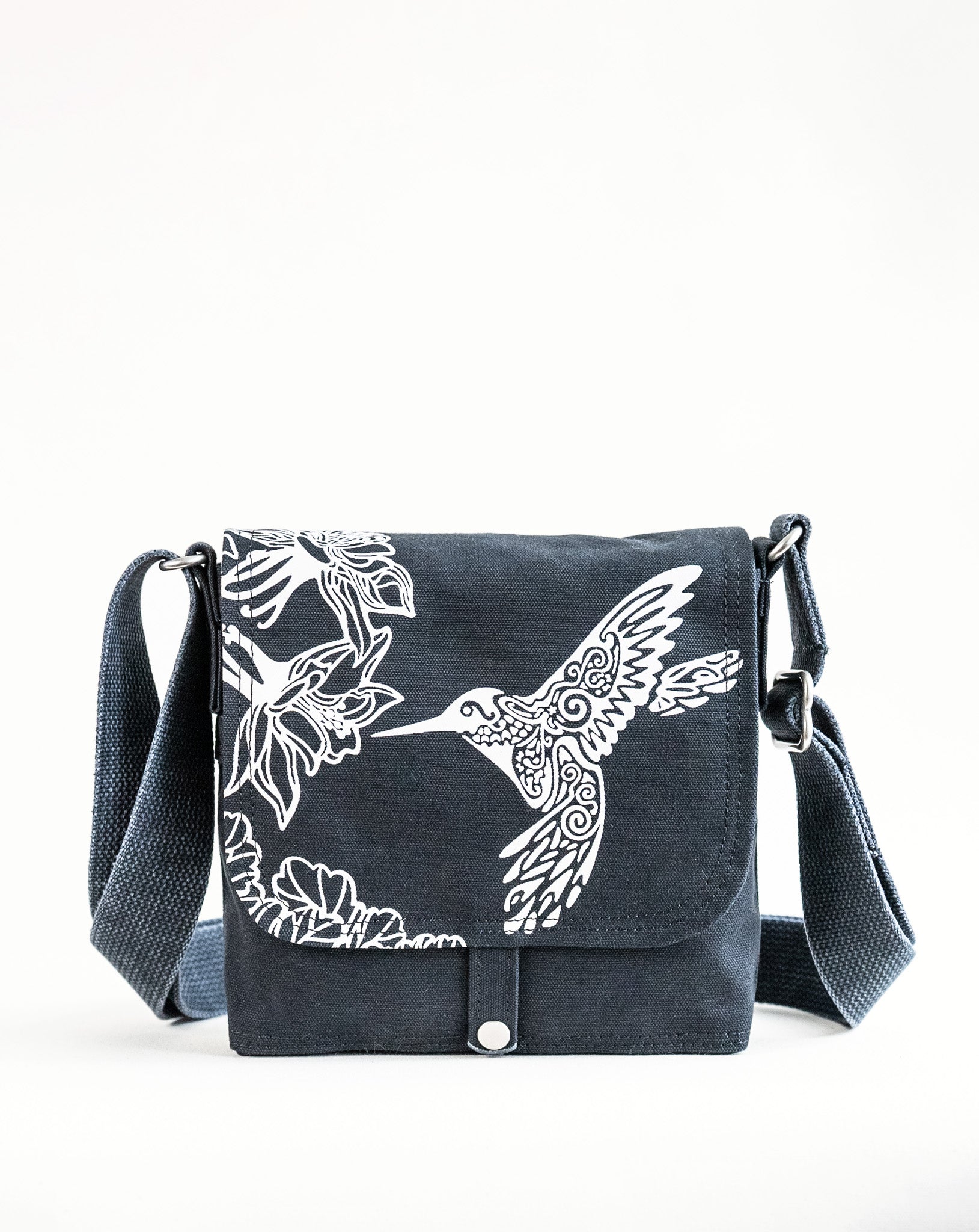 Front exterior of Dock 5’s Hummingbird Canvas Mini Messenger Bag in black featuring art from owner Natalija Walbridge