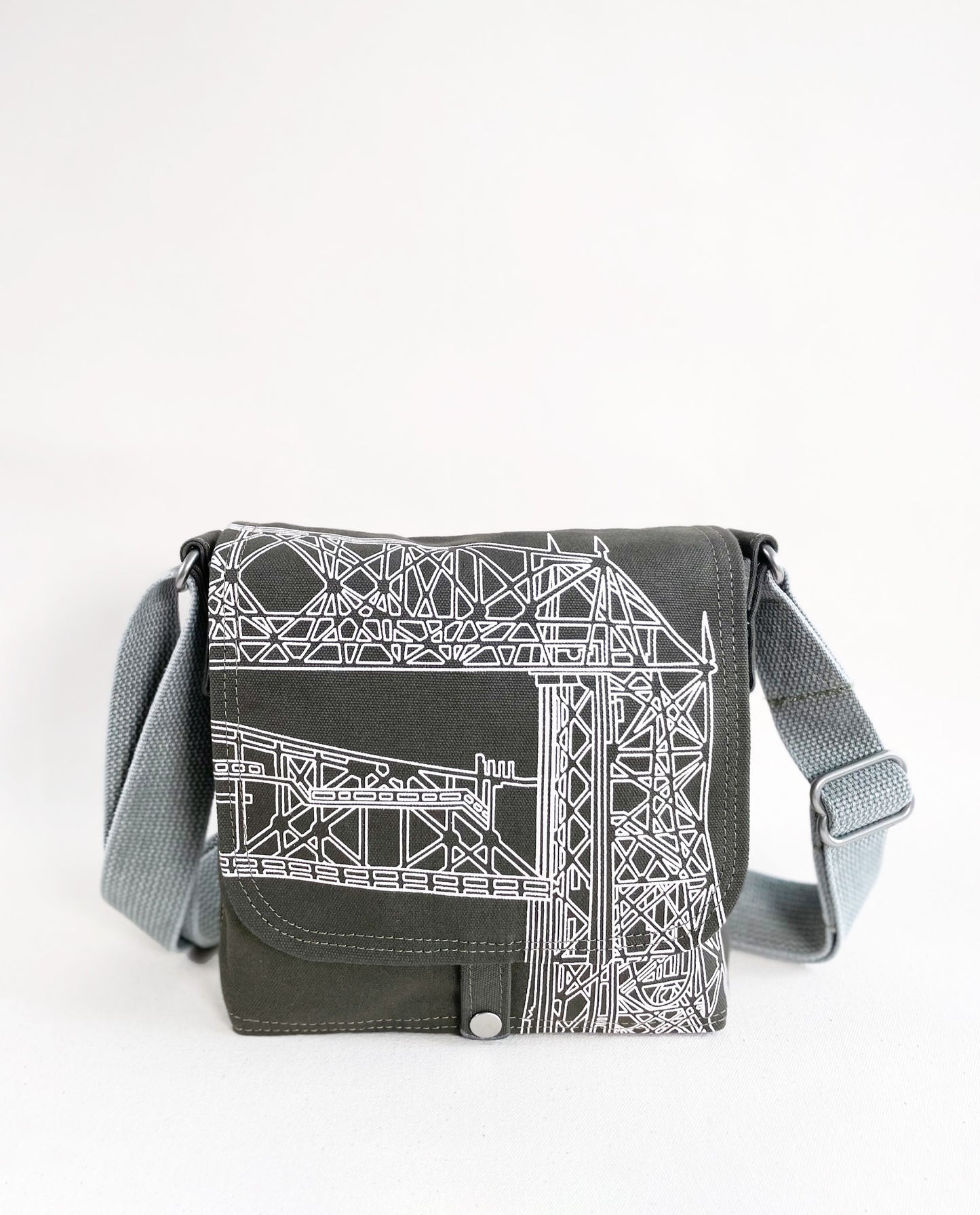 Front exterior of Dock 5’s Lift Bridge Canvas Mini Messenger Bag in olive featuring art from owner Natalija Walbridge