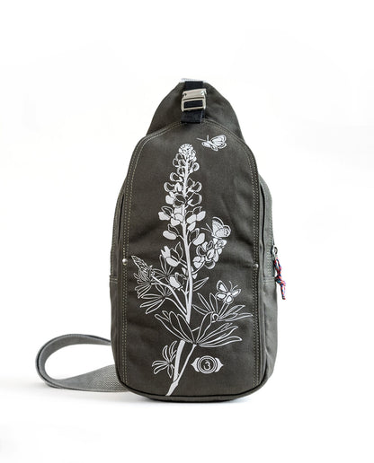 Front exterior of Dock 5’s Lupine Canvas Sling Bag in olive featuring art from owner Natalija Walbridge