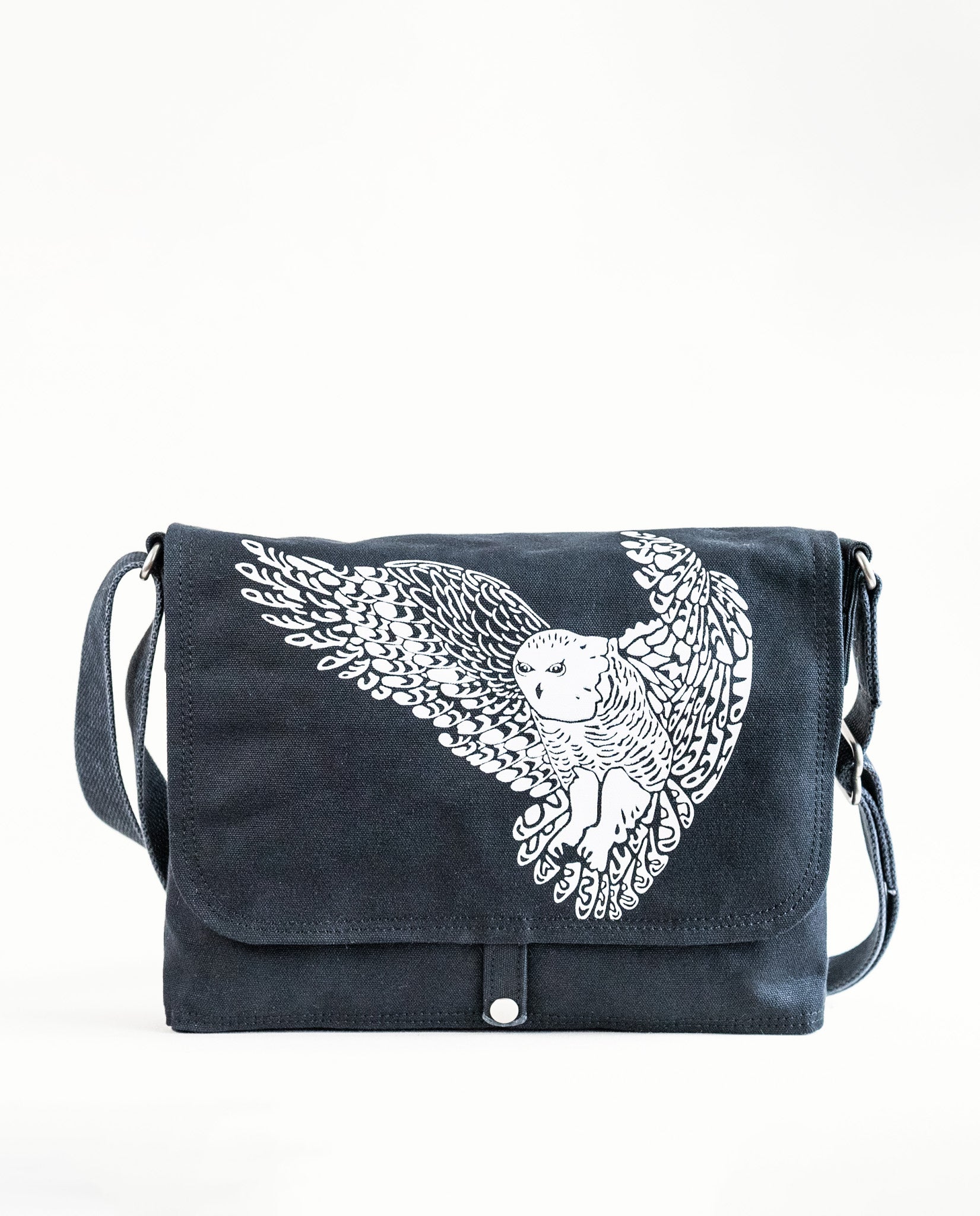 Front exterior of Dock 5’s Snowy Owl Canvas Messenger Bag in black featuring art from owner Natalija Walbridge