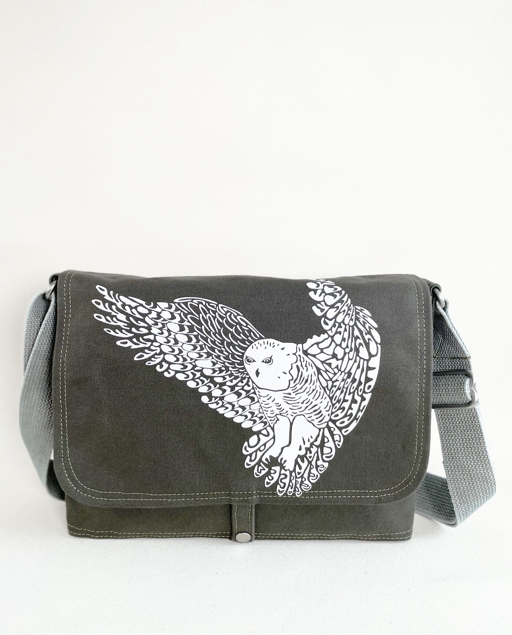 Front exterior of Dock 5’s Snowy Owl Canvas Messenger Bag in olive featuring art from owner Natalija Walbridge