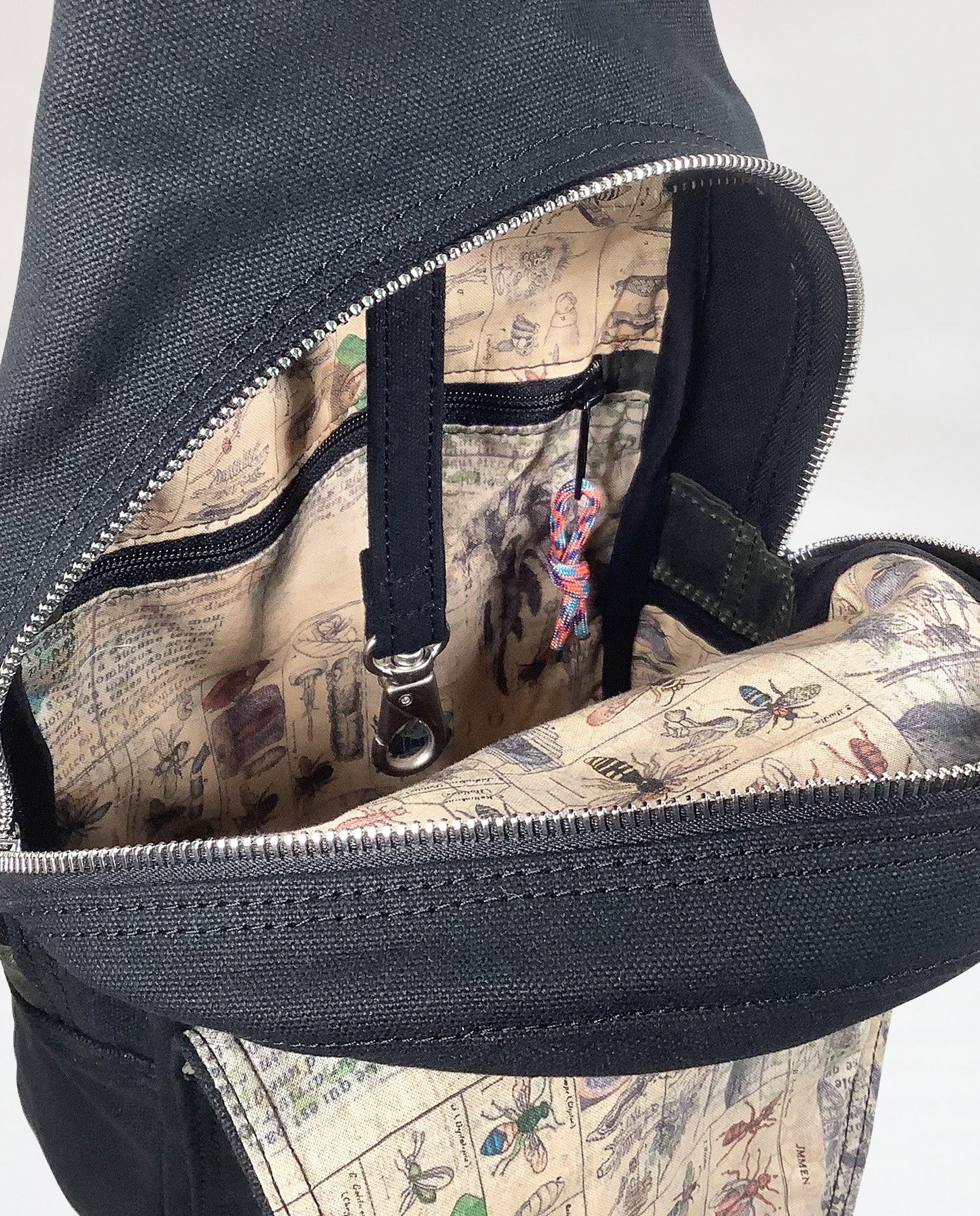 Interior of Dock 5’s Kingfisher Canvas Sling Bag in black featuring a leash for keys and a zipper pocket